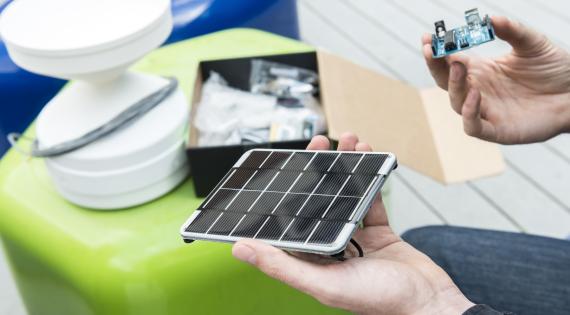 Hand holding solar panel and circuit board