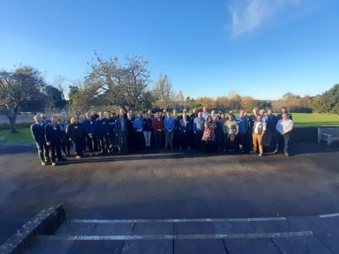 Attendees from the workshop standing under a blue sky