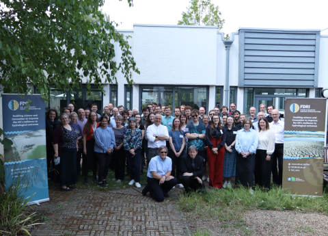 The FDRI team poses in front of a building