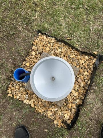 Aerial shot of a rain gauge with gravel surround