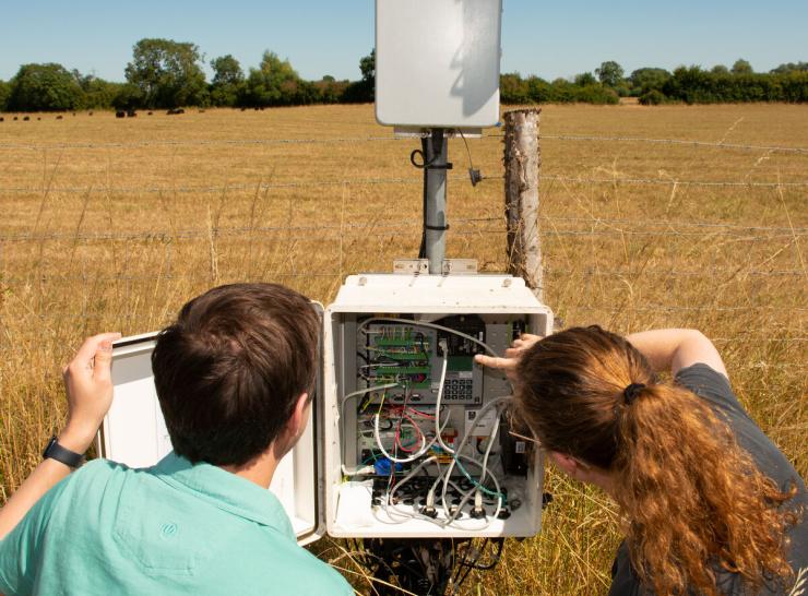 colleagues look at COSMOS hardware in a field