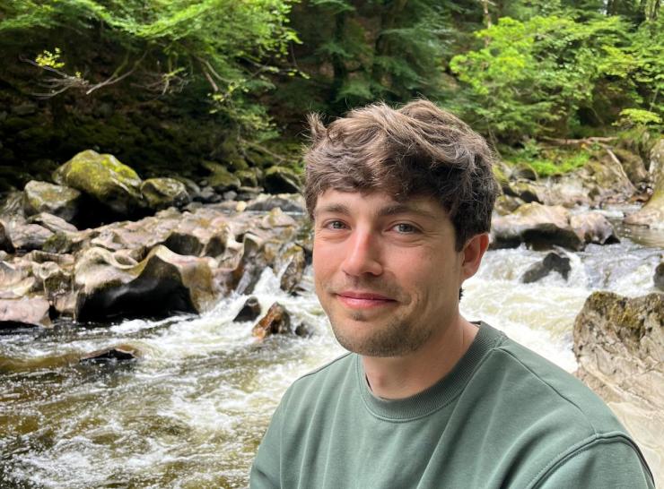 Simon smiling next to a river