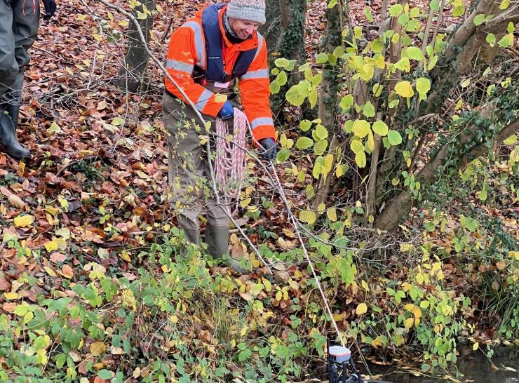 A technician uses an ADCP in the river